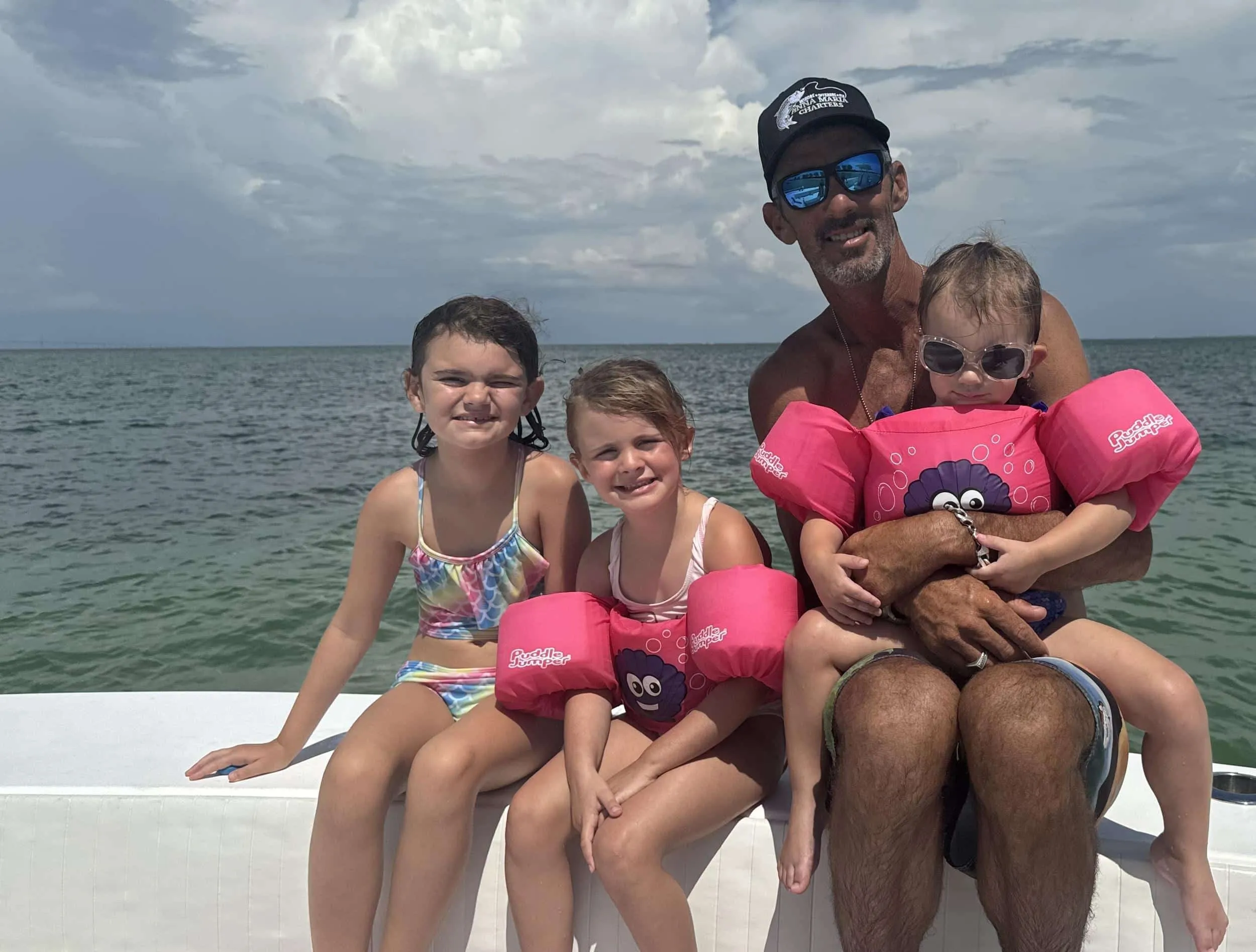 Captain David and his three girls on a boat