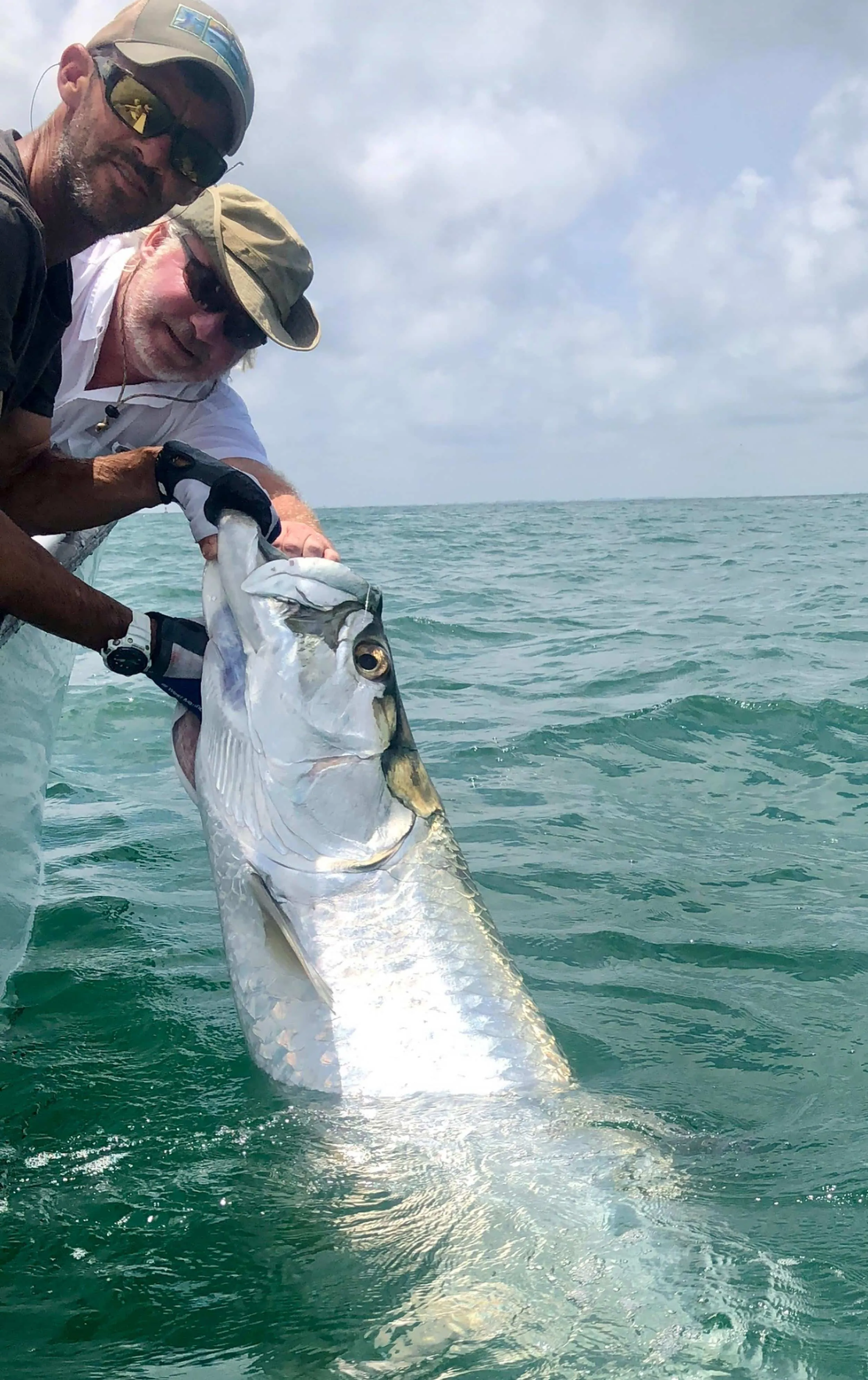 Angler with a tarpon aboard the boat