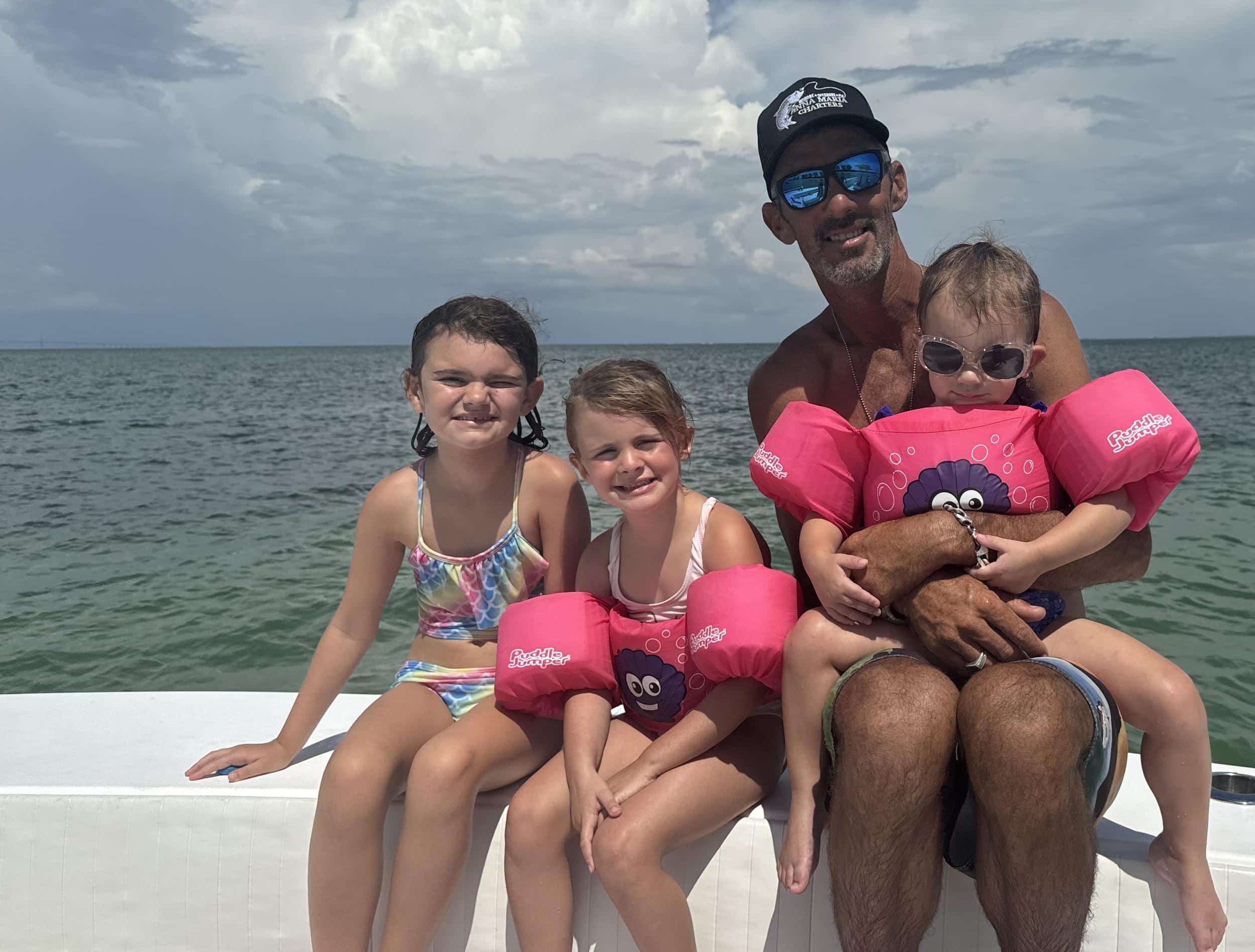 Captain David and his three girls on a boat